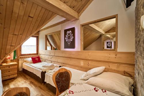 two beds in a room with wooden ceilings at Zakopianka in Zakopane