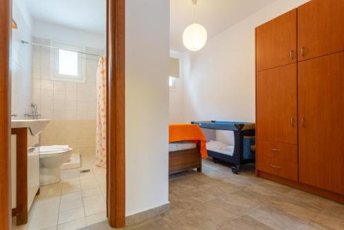 een badkamer met een wastafel, een toilet en een wastafel bij Villa Alexandra in Póros