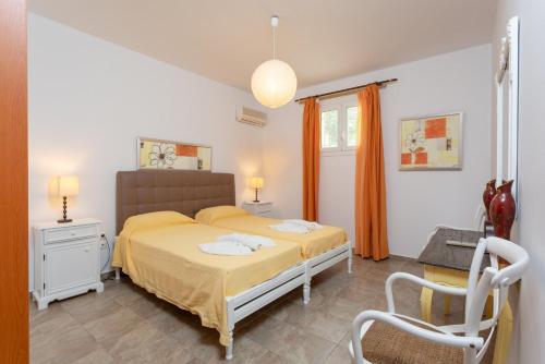 ポロスにあるVilla Alexandraのベッドルーム1室(ベッド1台、椅子付)