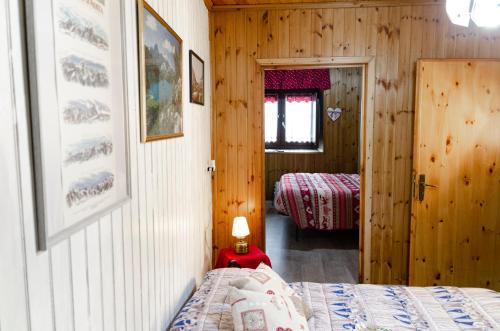 een slaapkamer met een bed in een houten hut bij Maison Rhémy - Relax e montagne in Saint-Rhémy-en-bosses