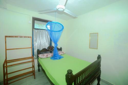 ein Zimmer mit einem Tisch mit einem blauen Objekt darauf in der Unterkunft Tony's Garden House Back Packers inn in Jaffna