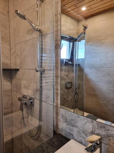 a shower with a glass door in a bathroom at Baltic Sea- domki z jacuzzi blisko natury in Władysławowo