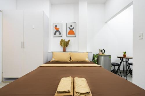 a large bed in a room with white walls at Ekomo Home 102 - Central Saigon in Ho Chi Minh City