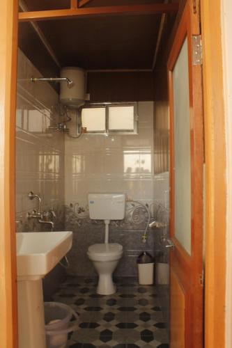 a small bathroom with a toilet and a sink at Ridge View Chalet Homestay in Darjeeling