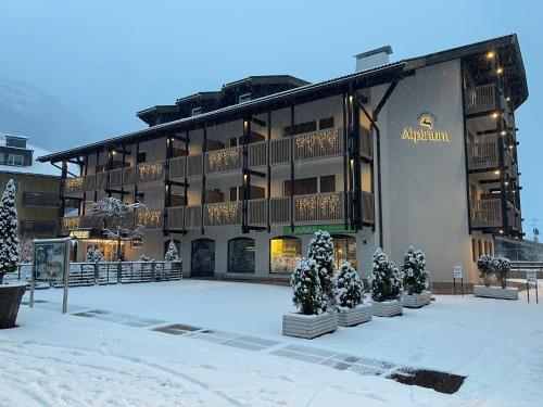 an apartment building with christmas trees in front of it at Residence Hotel Alpinum in Campo Tures