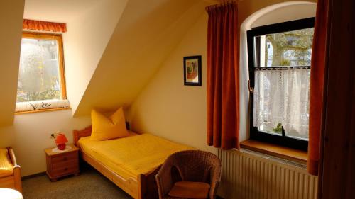 - une chambre avec un petit lit et une fenêtre dans l'établissement Villa Lydia, à Kurort Altenberg