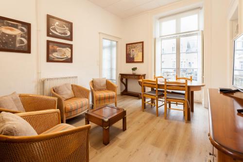 een woonkamer met een bank en een tafel bij Le Joffre - sur le port - wifi in Vannes