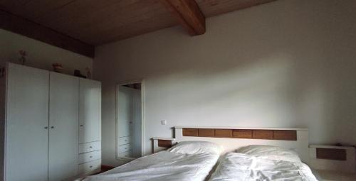 a bedroom with a bed with white sheets at FeWo Strohbrück in Quarnbek