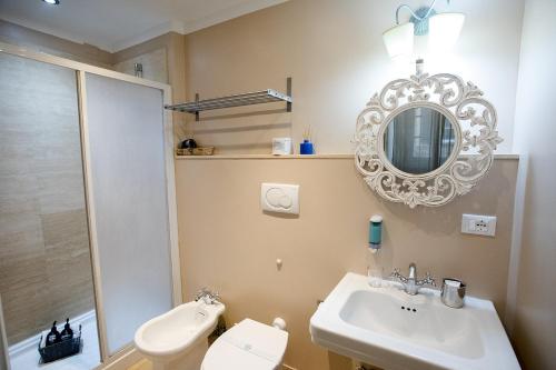 a bathroom with a sink and a toilet and a mirror at Residenza Centro Storico in Lucca