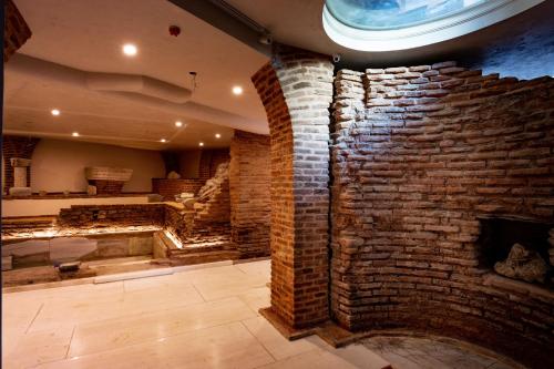 a room with a brick wall and a fireplace at Villa Flavia Heritage Boutique Hotel in Plovdiv