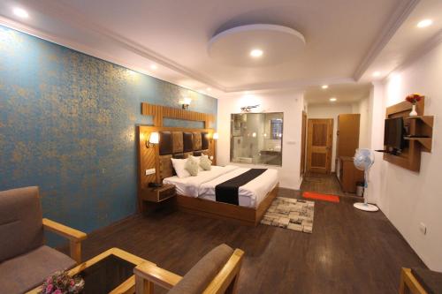 Habitación de hotel con cama y sala de estar. en Hotel NSB Manali, en Manali