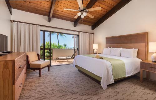 um quarto com uma cama grande e uma televisão em Kona Coast Resort em Kailua-Kona