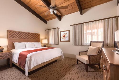 a bedroom with a large bed and a desk and chair at Kona Coast Resort in Kailua-Kona