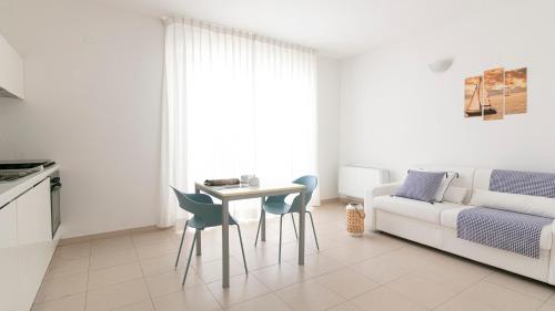 a living room with a table and chairs and a couch at Residenza Excelsior - Bilocali Piano Terra in Marina di Montenero