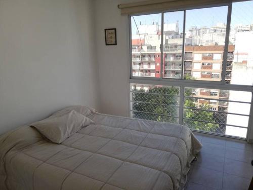 1 dormitorio con cama y ventana grande en Luminoso piso 10 con cochera en Mar del Plata