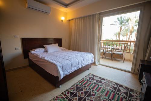 a bedroom with a bed and a balcony with a view at Palma Resort Hurghda in Hurghada