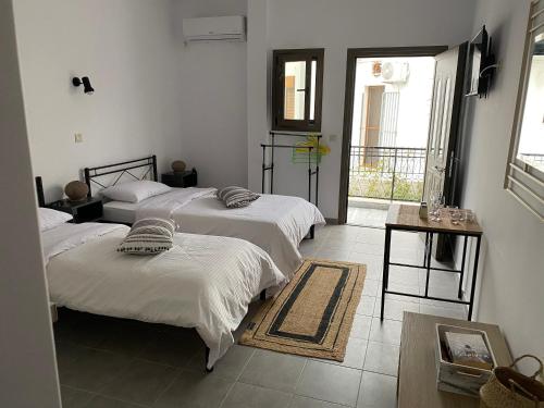 a bedroom with three beds and a balcony at Mani Spot in Areopoli