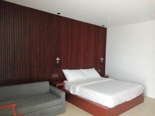 a bedroom with a bed and a couch in it at Beach house by Rose massage in Nai Thon Beach