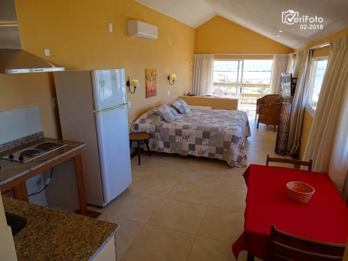 cocina y dormitorio con cama y nevera. en Hotel Aquarella, en Punta del Diablo