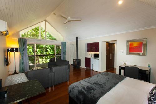 - une chambre avec un lit et un salon dans l'établissement Songbirds Rainforest Retreat, à Mount Tamborine
