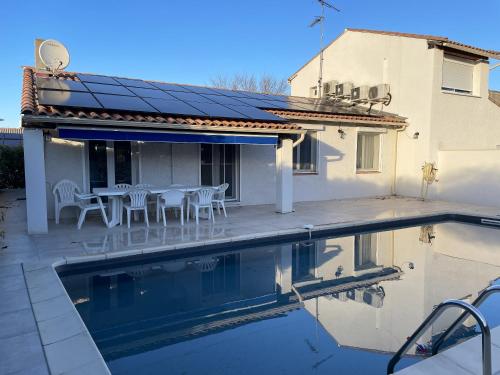 una casa con piscina frente a una casa en Maison d'une chambre avec piscine privee jardin clos et wifi a La Calmette, en La Calmette