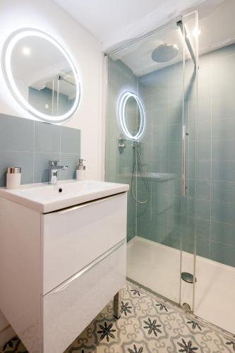 une salle de bain avec un lavabo et une douche dans l'établissement La Coquette - Tout confort - 100m du Canal - Calme - Wifi, à Malestroit