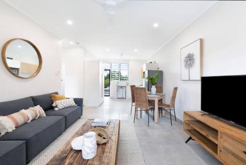 ein Wohnzimmer mit Sofa und Tisch in der Unterkunft 'Botanica Aguila' Chic Nightcliff Balcony Pad in Darwin