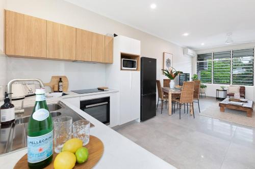 a kitchen with a bottle of wine on a counter at 'Botanica Aguila' Chic Nightcliff Balcony Pad in Darwin