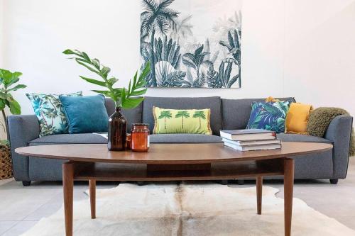 a living room with a couch and a coffee table at 'Botanica Paradiso' A Vibrant Nightcliff Solace in Darwin