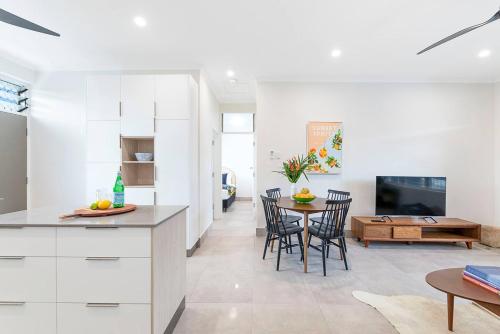 a kitchen and living room with a table and chairs at 'Botanica Paradiso' A Vibrant Nightcliff Solace in Darwin