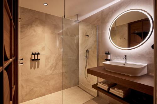 een badkamer met een wastafel en een douche bij Van der Valk Hotel Lelystad in Lelystad