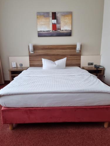a bedroom with a large bed and two night stands at Hotel Bavaria Oldenburg in Oldenburg