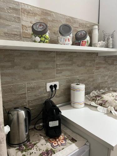 eine Küchentheke mit einem Toaster und einem Wasserkocher in der Unterkunft Amalia B&b San francesco in Bari