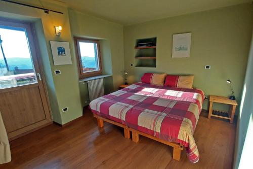 1 dormitorio con 1 cama con colcha colorida en Cascina Nomade, en Dogliani