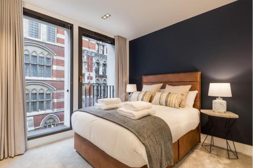 a bedroom with a bed and a large window at Synergy The Strand in London