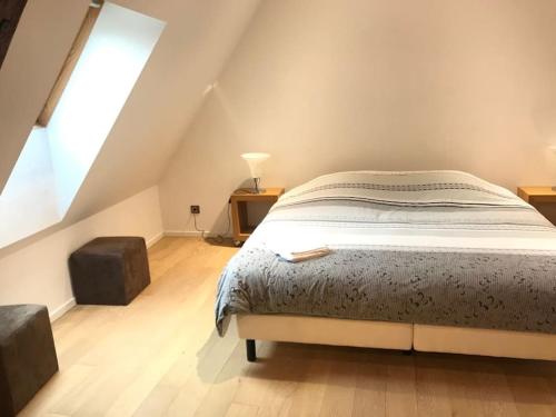 a bedroom with a bed and a large window at L'Appartement des Artistes avec Terrasse in Kaysersberg