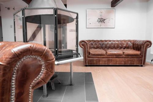 - un salon avec un canapé en cuir et un miroir dans l'établissement L'Appartement des Artistes avec Terrasse, à Kaysersberg