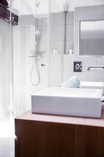 une salle de bain avec un lavabo blanc et un miroir dans l'établissement L'Appartement des Artistes avec Terrasse, à Kaysersberg