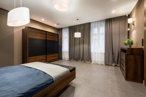 sypialnia z łóżkiem, komodą i oknem w obiekcie Apartament PLATYNOWY - Centrum Gliwic z parkingiem w mieście Gliwice