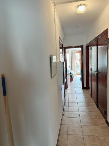 a hallway with a white wall and a tile floor at Appartement centre ville in Tournai