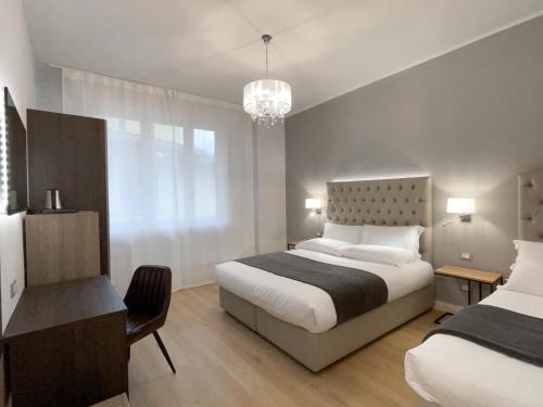 1 dormitorio con 2 camas y lámpara de araña en Domus Uffizi en Florence