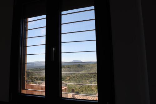 a window with a view of a field through it at Ca ma mare in Useras