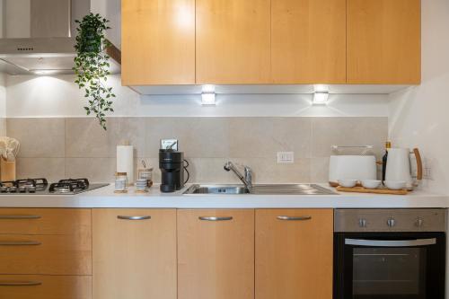 een keuken met houten kasten en een spoelbak bij Art Design Home Firenze in Florence