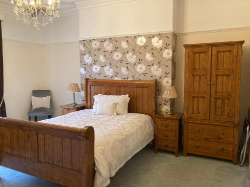 a bedroom with a bed and a floral wall at The Corner House Bed & Breakfast in Whitehaven
