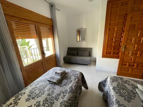 a room with two beds and a door with a chair at APARTAMENTO VERA playa in Vera