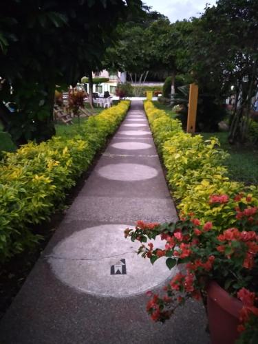 a walkway in a park with flowers and plants at Hotel Las Victorias Palmira in Palmira