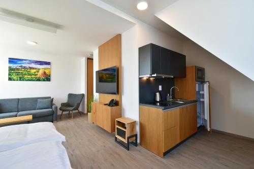 a hotel room with a king sized bed and a kitchen at Rezort Maladinovo pri Liptovskej Mare in Liptovský Mikuláš