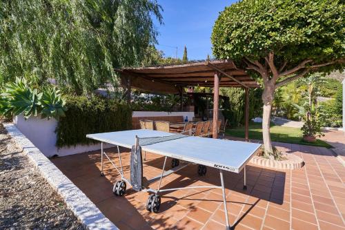 a ping pong table sitting on a brick patio at Group Villa 14 Pool wifi Air in Frigiliana