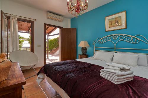a blue bedroom with a bed with towels on it at Group Villa 14 Pool wifi Air in Frigiliana