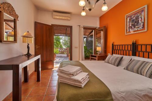 Un dormitorio con una cama y un escritorio con toallas. en Group Villa 14 Pool wifi Air en Frigiliana